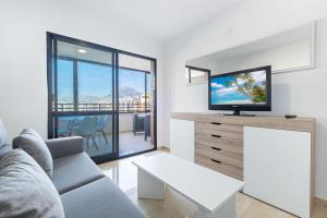 ein Wohnzimmer mit Sofa und Fernseher in der Unterkunft Trinisoll II 6-C Sea views Apartment Levante Beach in Benidorm