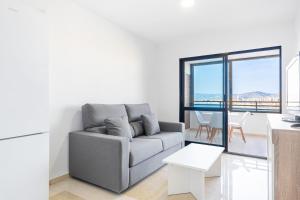 ein Wohnzimmer mit Sofa und Tisch in der Unterkunft Trinisoll II 6-C Sea views Apartment Levante Beach in Benidorm