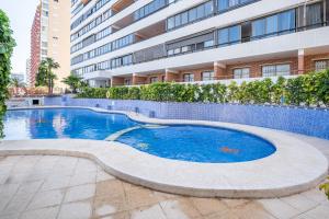 ein Schwimmbad vor einem Gebäude in der Unterkunft Trinisoll II 6-C Sea views Apartment Levante Beach in Benidorm