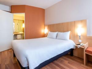 a large white bed in a hotel room at ibis Toulouse Aeroport in Blagnac