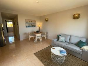 a living room with a couch and a table at Casa Cayenne - Stylish apartment with ocean/dune view in Corralejo