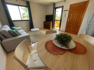 a living room with a table and a couch at Casa Cayenne - Stylish apartment with ocean/dune view in Corralejo