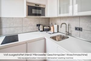 uma cozinha com armários brancos e um lavatório em "Neptunblick"- Nähe Altstadt - Ruhig - Klinikum em Dresden