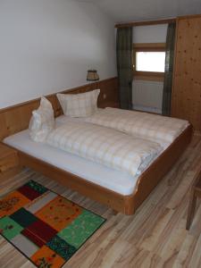 a bed in a room with a wooden floor at Gasthof Hauserwirt in Wörgl