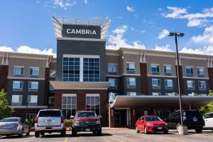Cambria Hotel Ft Collins في فورت كولينز: فندق فيه سيارات متوقفة في مواقف