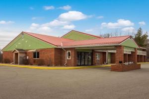 a red brick building with a green roof at Econo Lodge by Choicehotels in Cadillac