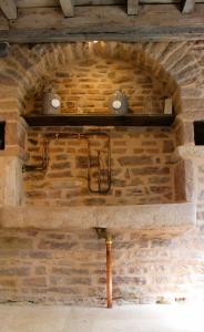 una pared de ladrillo con dos velas en un estante en LE CLOS DES PIERRES ROUGES, en Burgy