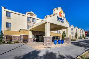 a front view of a hotel with trash cans at Comfort Inn & Suites Near Worlds of Fun in Kansas City