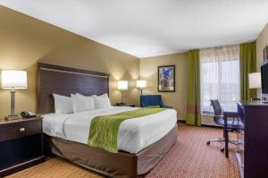 a hotel room with a large bed and a desk at Comfort Inn & Suites Near Worlds of Fun in Kansas City