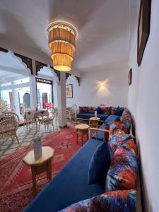 een woonkamer met blauwe banken en een tafel bij Riad Malfa in Marrakesh