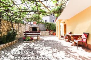 an outdoor patio with a table and a fireplace at Relax Apartments - Big Terace & Grill in Vrsar