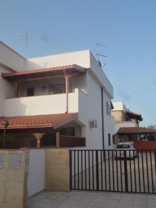 a white house with a fence in front of it at La vedetta in San Pietro in Bevagna