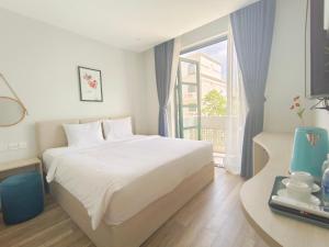 - une chambre avec un lit blanc et une fenêtre dans l'établissement Minh Anh Hotel, à Duong Dong