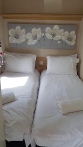 two beds in a room with white sheets and pillows at Mountain View in Millom