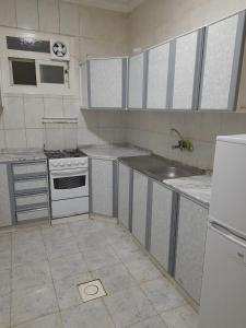 una cocina vacía con fogones y fregadero en Bait Alsadaqa Aparthotel, en Abha