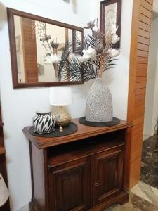 een spiegel bovenop een houten kast met vazen bij Sud Est Bed And Breakfast Salento in Sternatia