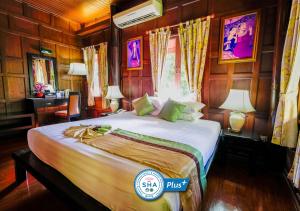 a bedroom with a large bed in a room at Baan Amphawa Resort & Spa - SHA Certified in Amphawa +64 photos
