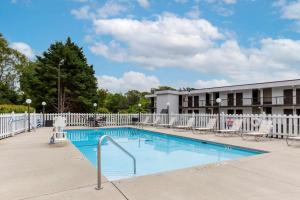a pool at a hotel with chairs and a building at Quality Inn - Roxboro South in Roxboro