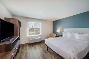 a bedroom with a bed and a flat screen tv at WoodSpring Suites Round Rock-Austin North in Round Rock