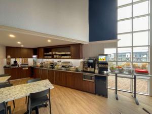 a large kitchen with wooden cabinets and a large window at Clarion Pointe Quebec Airport in Quebec City