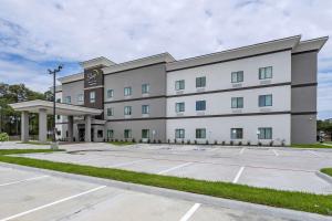 um grande edifício com um parque de estacionamento em frente em Sleep Inn & Suites em Crosby