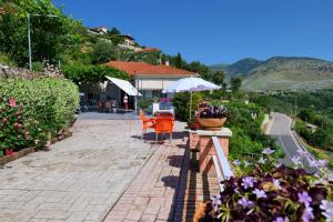 - une terrasse avec une table, des chaises et des fleurs dans l'établissement Saranda Landscape, à Nivicë