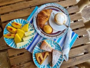 a table with three plates of bread and a cup of coffee at Albatros B&B Porto Cesareo in Porto Cesareo