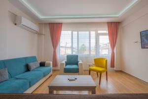a living room with a blue couch and two chairs at Infinity Oldtown Apartment, Located in City Center in Fethiye