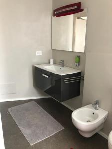 a bathroom with a sink and a toilet at Appartamenti il borgo papavero in Busca
