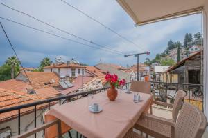a table with a vase of flowers on a balcony at Infinity Oldtown Apartment, Located in City Center in Fethiye