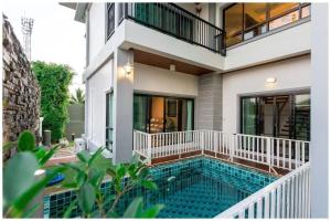 a house with a swimming pool in front of a house at Richly's​ Pool​ villa​@Phitsanulok​ in Phitsanulok