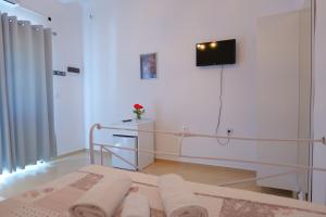 - une chambre avec un lit et une télévision murale dans l'établissement Saranda Landscape, à Nivicë