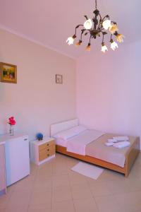 - une chambre avec 2 lits et un lustre dans l'établissement Saranda Landscape, à Nivicë