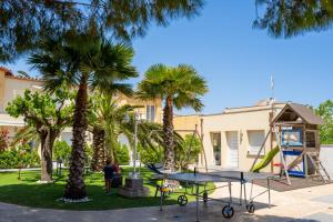 a ping pong table in a park with palm trees at La Vida Sin Limites EMP in Empuriabrava