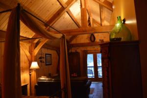 Cette chambre dispose d'un plafond en bois, d'un canapé et d'une fenêtre. dans l'établissement Shadow Mountain Escape Cabin Rentals, à Luray