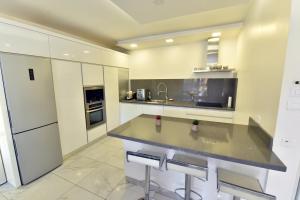 a kitchen with white cabinets and a counter top at Royal Park Eilat apartments in Eilat