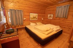 1 dormitorio con 1 cama en una cabaña de madera en Myraleited 40 en Tjørhom