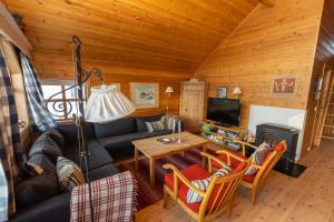 a living room with a couch and a tv in a cabin at Myraleited 40 in Tjørhom