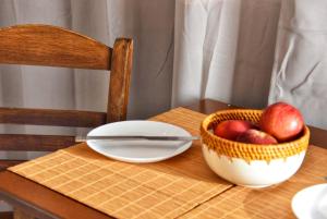 una mesa con un tazón de manzanas y un cuchillo en Anemomylos Apartments, en Lixouri