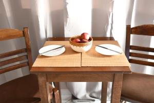uma mesa com dois pratos e uma tigela de maçãs em Anemomylos Apartments em Lixúri