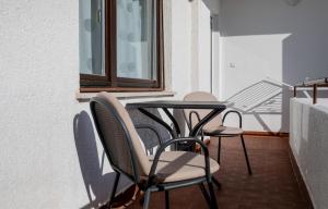 a table and chairs on a balcony with a window at B&B Sabina Rooms & Apartments in Rab
