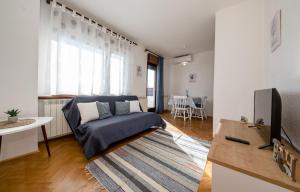 a living room with a couch and a tv at B&B Sabina Rooms & Apartments in Rab