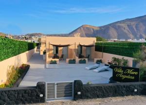 a house with a patio with a sign on it at Villa Mare Angelica in Perivolos