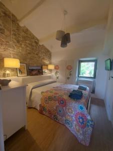 a bedroom with a bed and a stone wall at I Colori del Lago in Passignano sul Trasimeno