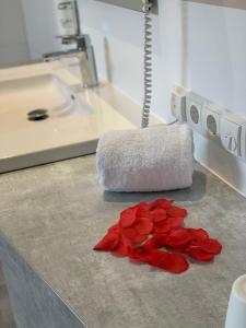 una pila de rosas rojas en un mostrador en un baño en Thöles*** Hotel in Vilsen en Bruchhausen-Vilsen