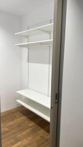 un armario con estanterías blancas y suelo de madera en Kamel club restaurace a penzion en Olomouc
