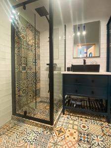 ein Bad mit einem Waschbecken und einer Glasdusche in der Unterkunft Apartament TURKUS in Puck
