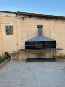 a grill sitting in front of a building at Masia La Bomba in Masnou