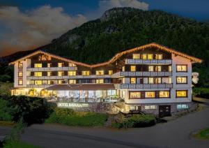 a large hotel with a mountain in the background at Familotel Bavaria Pfronten-Familien Hotel-Alles Inklusive Konzept in Pfronten