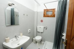 a bathroom with a sink and a toilet and a mirror at GK Houses #2 in Asprovalta +27 photos